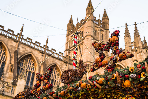 Christmas fruit garlands decorating a stall at Bath Christmas market with Bath Abbey in the background.