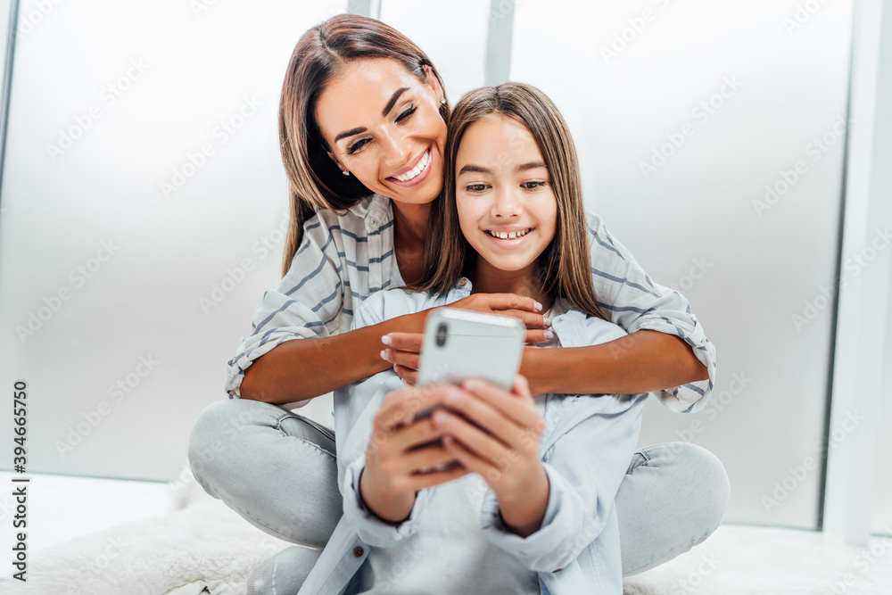 Smiling mother and daughter spend time together on the phone Smiling mother and daughter spend time together on the phone