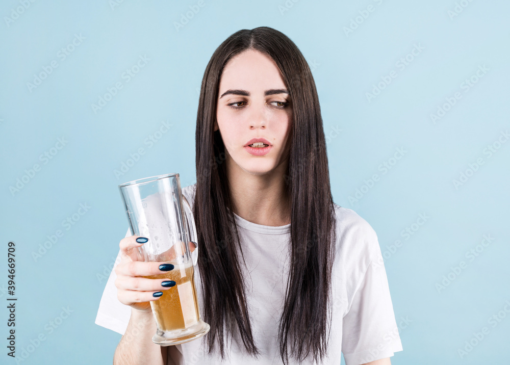 Young woman drinking jar of beer standing over blue background looking sleepy and tired, exhausted for fatigue and hangover, lazy eyes in the morning. Young woman drinking jar of beer standing over blue background looking sleepy and tired, exhausted for fatigue and hangover, lazy eyes in the morning.