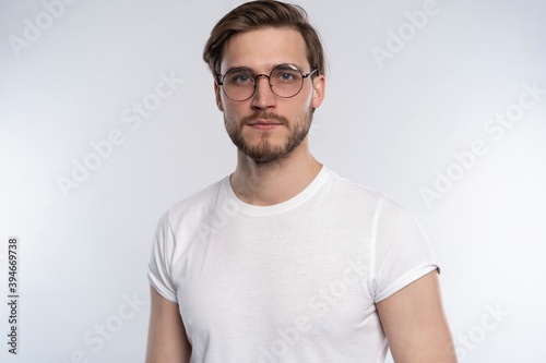 Portrait of a smart young man standing against white background. © opolja