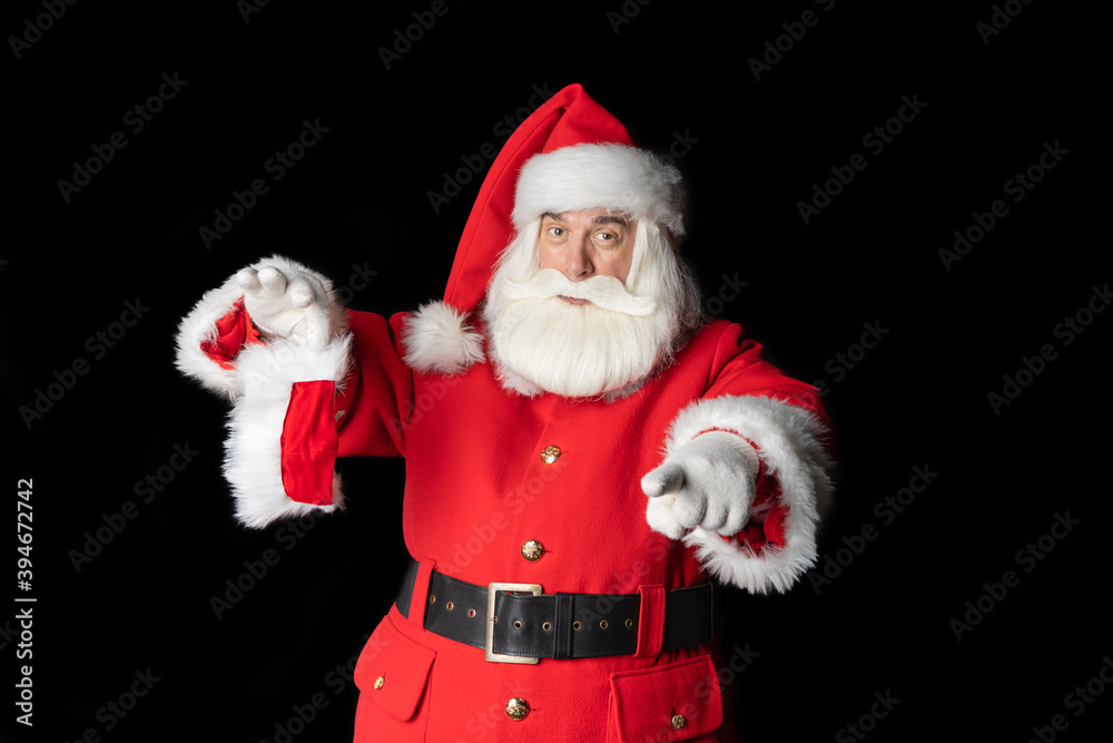 Santa Claus shows with his finger to wear a mask. Black background. Santa Claus shows with his finger to wear a mask. Black background.