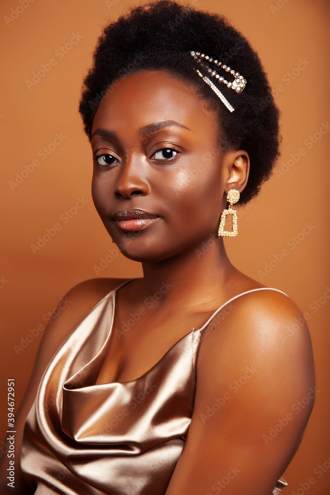 young pretty african model with golden jewelry in fashion style dress smiling happy on brown backround, lifestyle people concept young pretty african model with golden jewelry in fashion style dress smiling happy on brown backround, lifestyle people concept