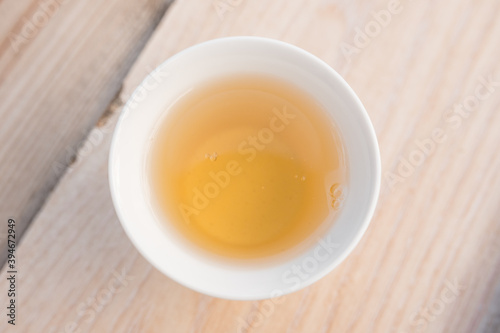 Beautiful porcelain tea cup close up shot. Hydrating pale liquor in it.
Fresh natural yellow tea. Top view.
