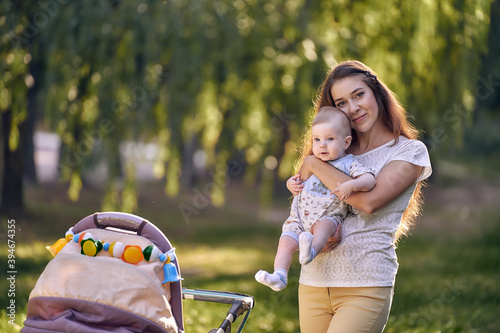 Young mother with her baby on a sunny meadow in a summer park. photo