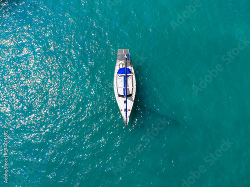 Foto Aerial wonderful view of a enormous white and blue yacht sailing across the blue