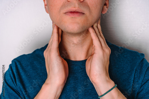 A man checks the lymph nodes on his neck. photo