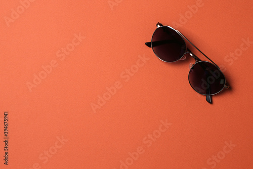 Male sunglasses on orange paper background. Men eyewear fashion concept.