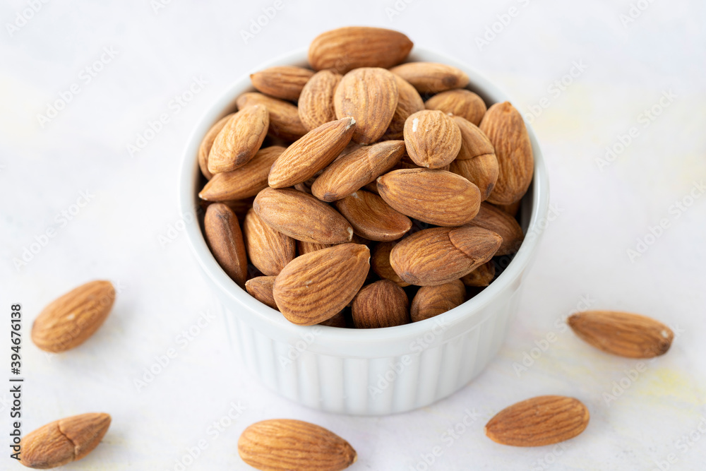 almonds in bowl - on wooden background almonds in bowl - on wooden background