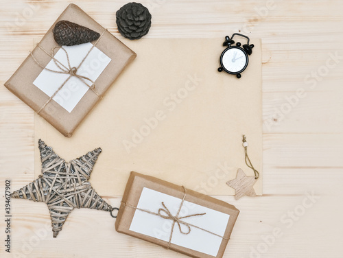 Zero waste Christmas flat lay. stylish simple christmas gifts in craft paper on rustic white table with christmas star and pine cones. alarm clock. Plastic free sustainable lifestyle. 