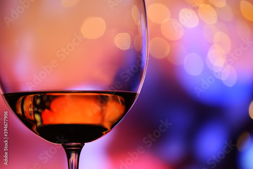 Glass with rose wine against a colorful festive background. The mood of the holiday, happiness and fun.
