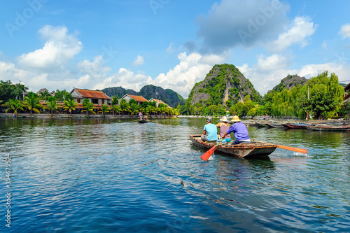 A boat carrying tourists on the river in the scenic Tam Coc Bich Dong, Ninh Binh province, Vietnam.