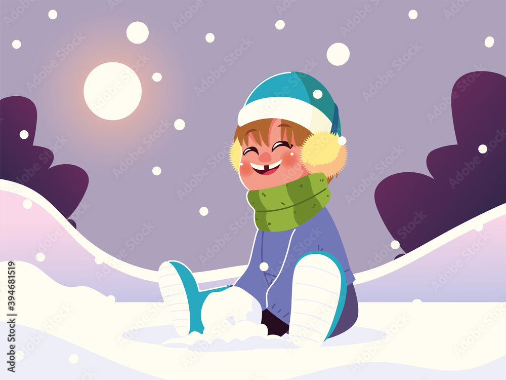 happy boy with warm clothes sitting in snow playing