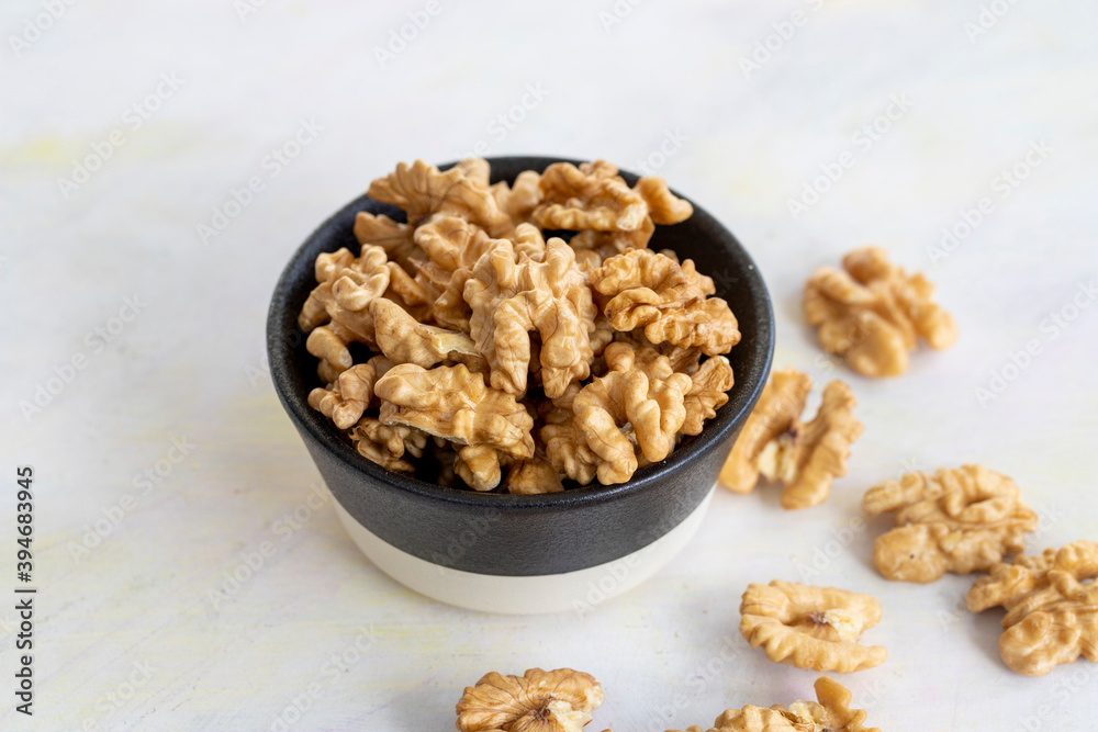 walnuts in bowl - on wooden background walnuts in bowl - on wooden background
