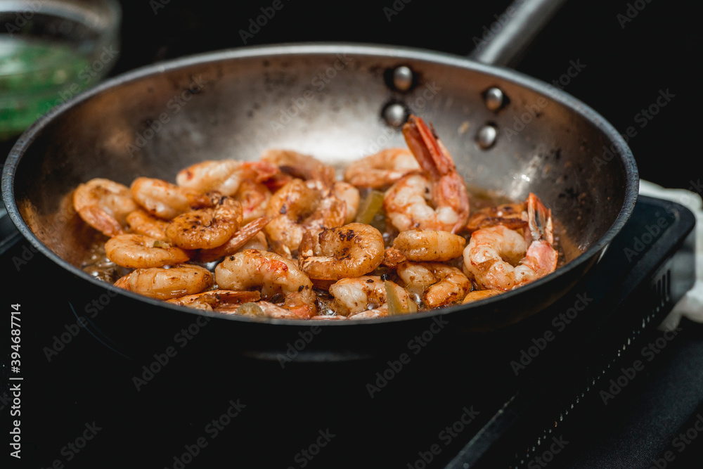 Shrimp on frying pan. Thermal processing of food. Electric cooker in a restaurant