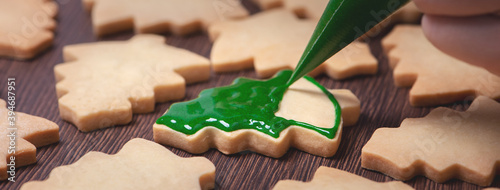 Valokuva Close up of drawing Christmas tree sugar cookie on wooden table background with icing