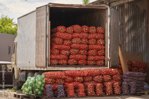 Street sale of vegetables from a truck. farmers market. bags of onions, potatoes and cabbage