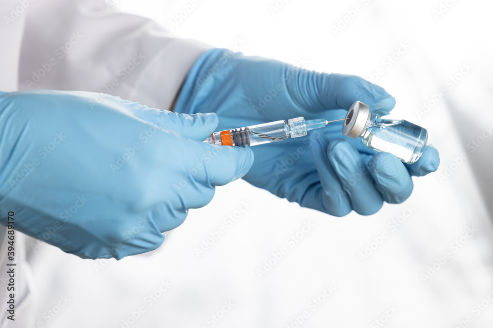 Doctor, nurse, scientist, researcher hand holding flu, measles, coronavirus, covid-19 vaccine preparing for human clinical trials vaccination shot, medicine and drug concept. Doctor, nurse, scientist, researcher hand holding flu, measles, coronavirus, covid-19 vaccine preparing for human clinical trials vaccination shot, medicine and drug concept.