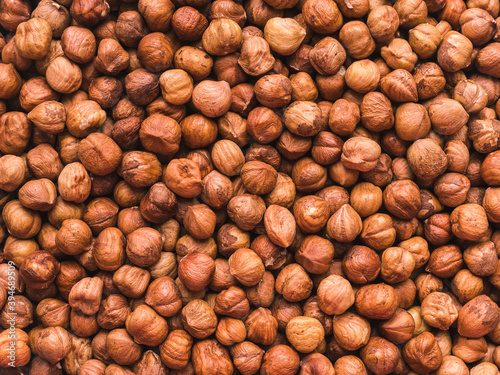 Canvastavla a lot of peeled hazelnuts without shells - food background
