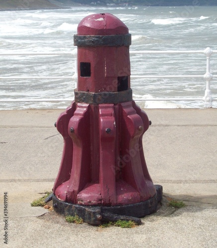 Red capstan winch with sea in background