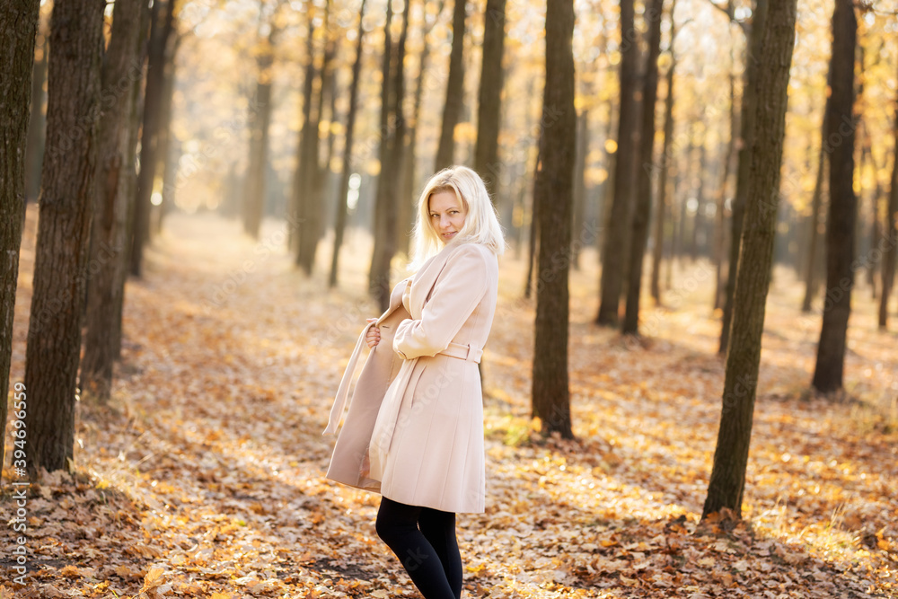 Happy middle-aged woman walking in the autumn park. Happy middle-aged woman walking in the autumn park.