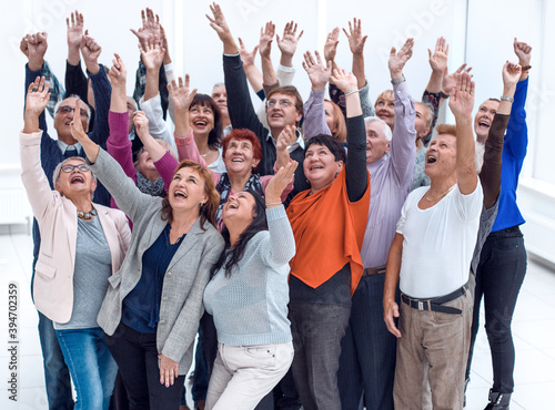a group of older people raised their hands trying to reach