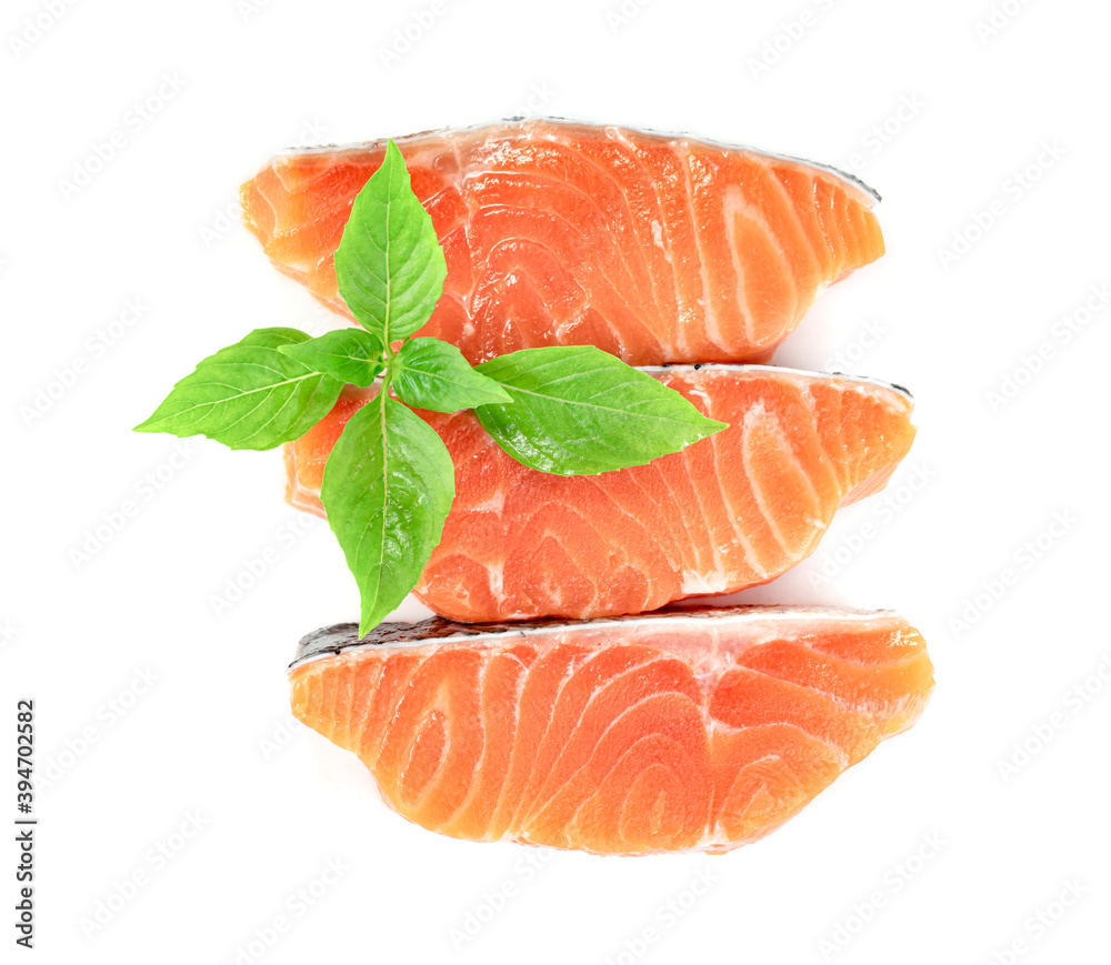 Piece of fresh salmon fillet sliced with leaf basil isolated on white background Piece of fresh salmon fillet sliced with leaf basil isolated on white background