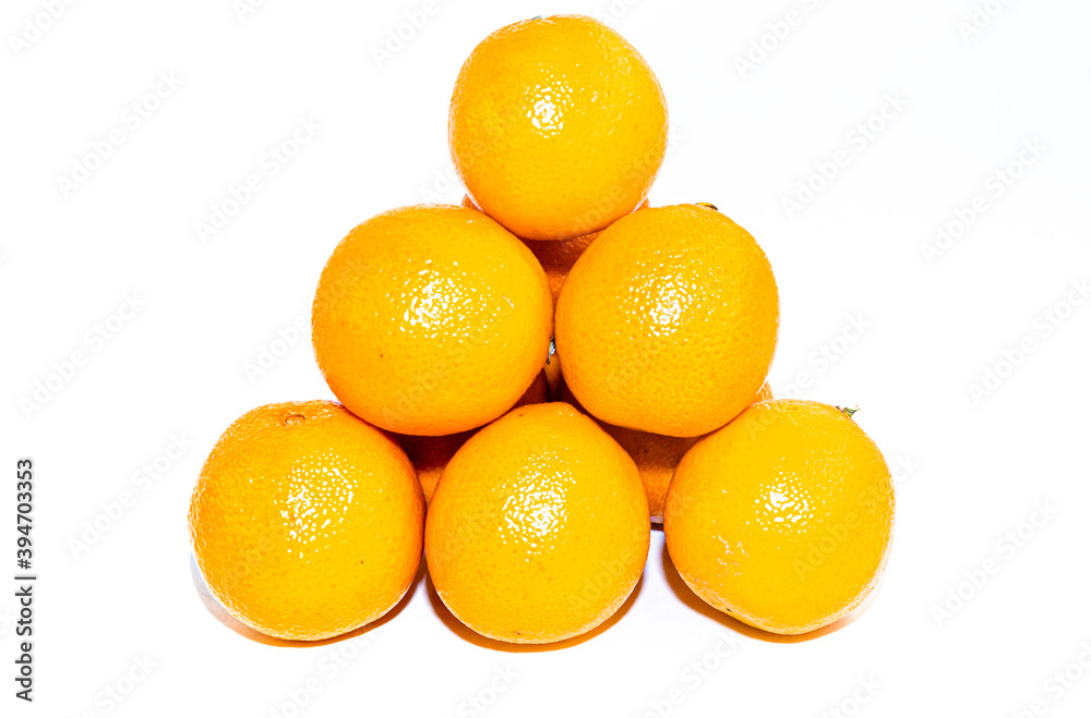 Pyramid of yellow orange ripe tangerines on a white backdrop Pyramid of yellow orange ripe tangerines on a white backdrop