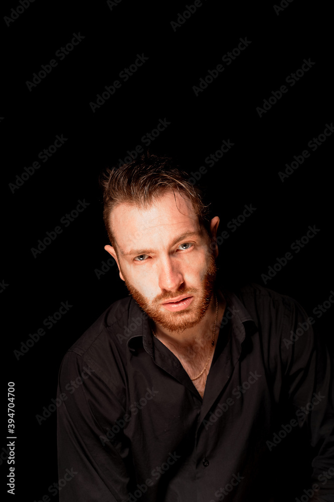 A man on a black background .Aggressive facial expression. Criminal personality