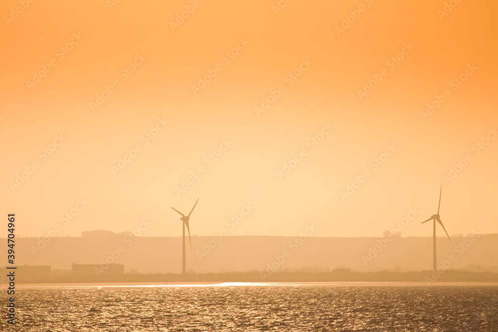 Wind turbines at dusk on the coat, England, United Kingdom