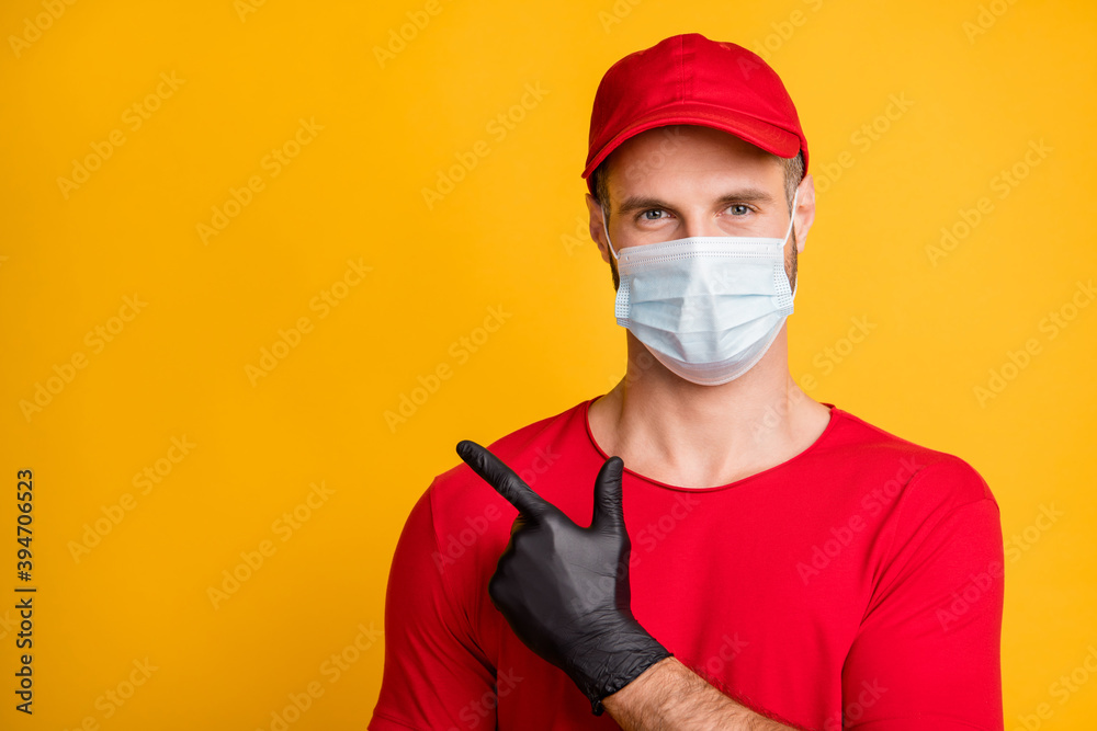 Photo of calm guy direct finger demonstrate empty space wear mask red t-shirt cap isolated yellow color background Photo of calm guy direct finger demonstrate empty space wear mask red t-shirt cap isolated yellow color background