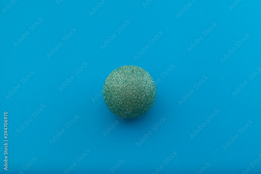 Shiny Christmas ball on a blue background. Selective focus, copy space