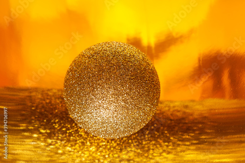 Sparkling golden christmas ball on abstract background  selective focus.  New year composition