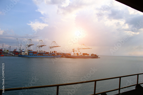 Ship container cargo entering commercial port, Logistics and transportation of container cargo ship and cargo logistic import export background and transport industry.sunset twilight
