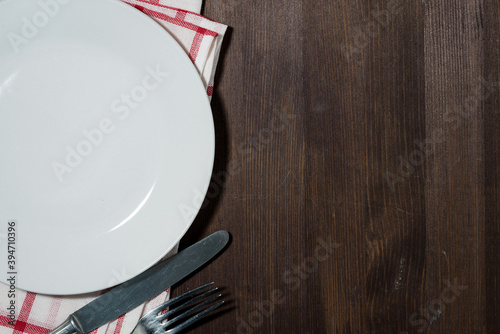 empty plate and cutlery, wooden background for recipes, top view
