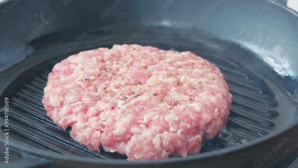 Close up view of chef putting raw mince patty on grill pan Close up view of chef putting raw mince patty on grill pan