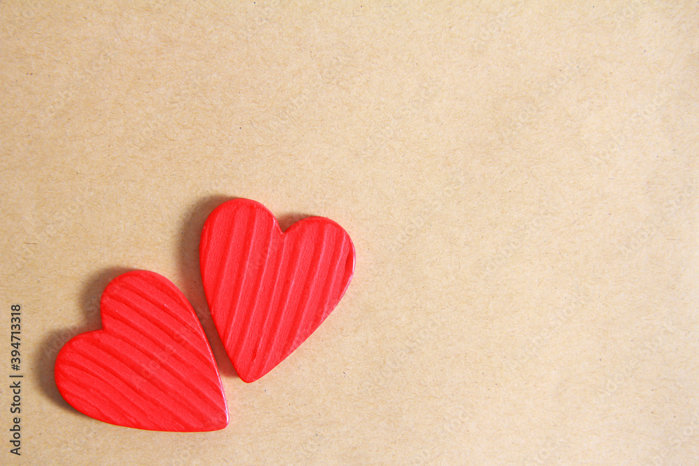 Two red wooden hearts on an old paper background. Creative greeting card for Valentine's Day. The view from the top. Flatly. Copy space.