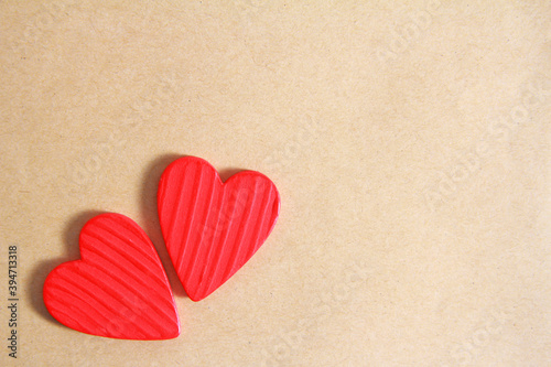 Two red wooden hearts on an old paper background. Creative greeting card for Valentine's Day. The view from the top. Flatly. Copy space.