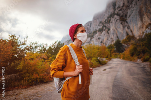 Outdoor fashion photo of young beautiful lady surrounded autumn forest in mountains