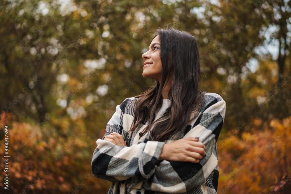 Beautiful happy woman smiling while strolling in autumn forest Beautiful happy woman smiling while strolling in autumn forest