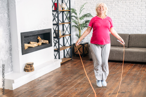 Photography Healthy and cheerful aging woman doing sports exercises in living room at home
