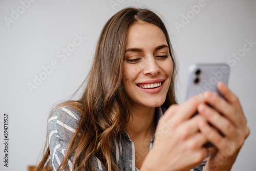 Happy beautiful woman smiling and using cellphone