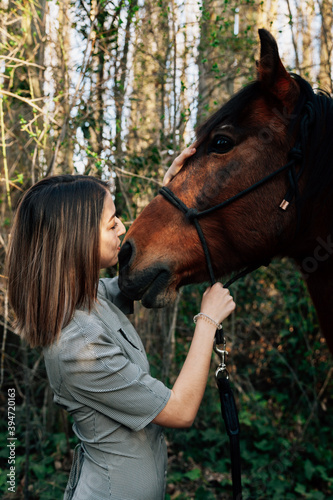 A woman caressing and talking to his horse in the countryside © Manu Reyes