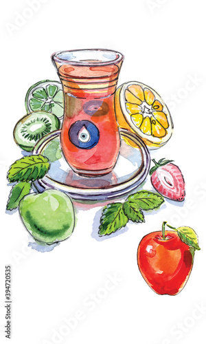 Turkish apple tea in traditional glass cup with fresh fruit and lemon balm