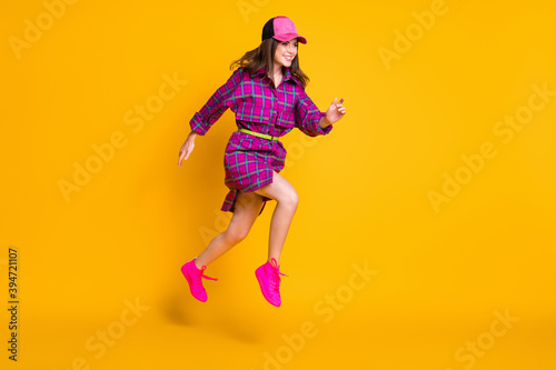 Full length photo of student running empty space wear cap violet plaid outfit isolated on yellow color background