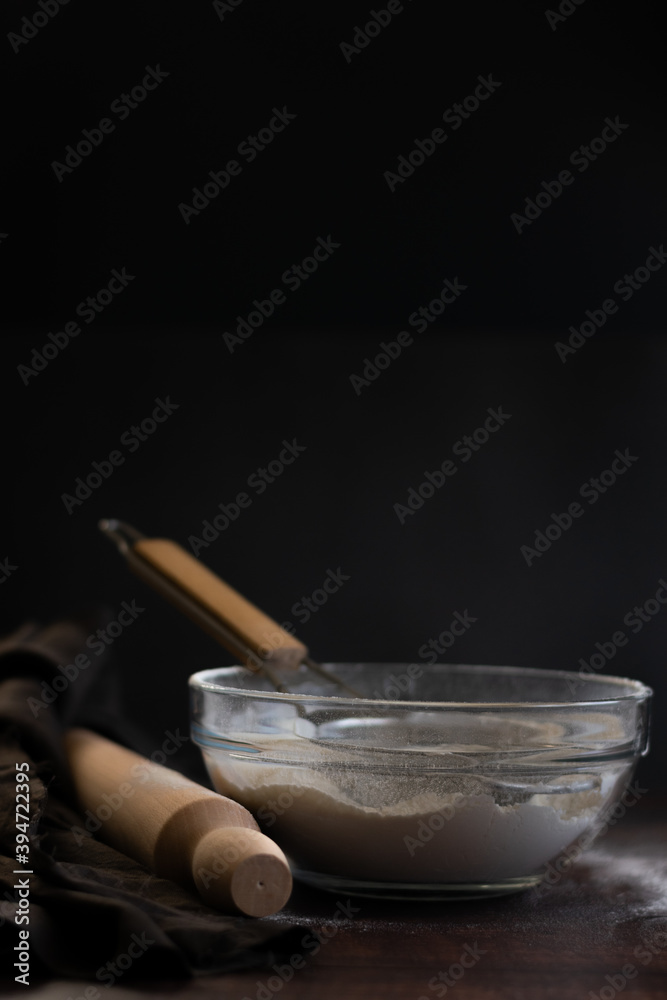 Bakery items - flour and eggs on dark background, healthy basic baking ingredients. Space for text Bakery items - flour and eggs on dark background, healthy basic baking ingredients. Space for text