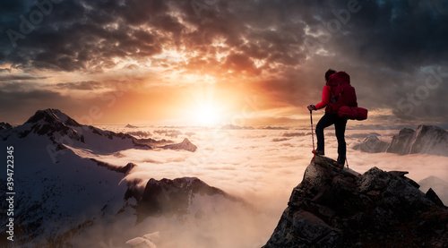 Girl Backpacker on top of a Mountain Peak. Dreamscape Artistic Render Composite. Landscape background from British Columbia, Canada. Dark Dramatic Sunrise Sky.