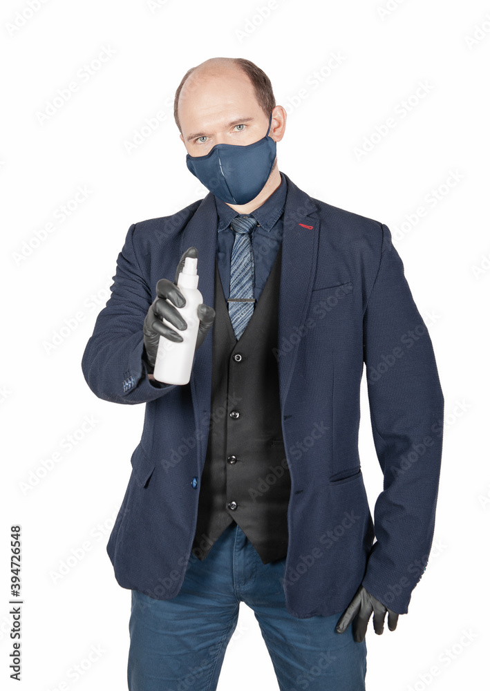 Handsome young business man with surgical medical virus protection mask and black gloves holding antiseptic bottle isolated