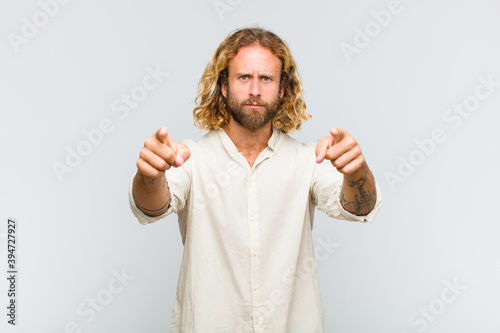 blonde man pointing forward at camera with both fingers and angry expression, telling you to do your duty photo