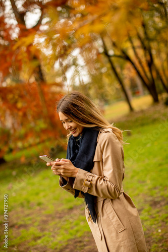 Young woman using mobile phone in the autumn park © BGStock72