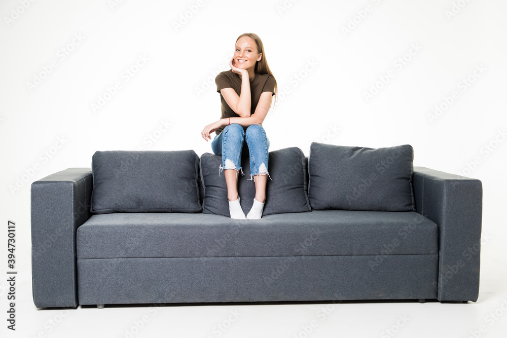 Beautiful young woman relaxing on a white sofa with a cup of coffee